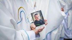 A priest holds a prayer card of Blessed Stanisław Streich at the Beatification Mass on May 24, 2025